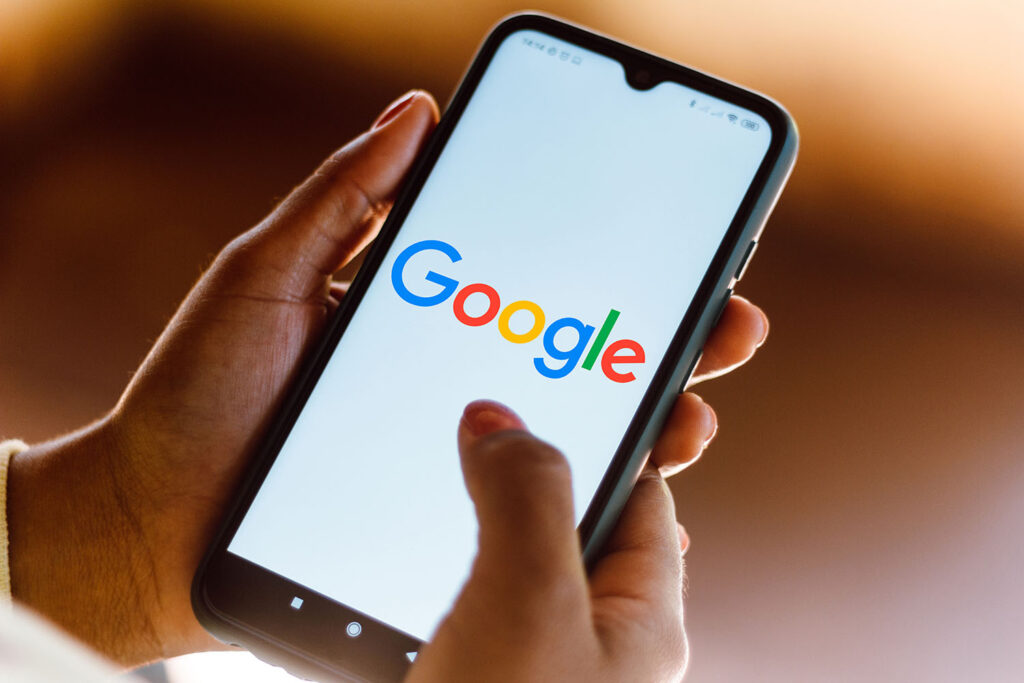 Man using Google on his mobile phone to research the latest helpful content update.