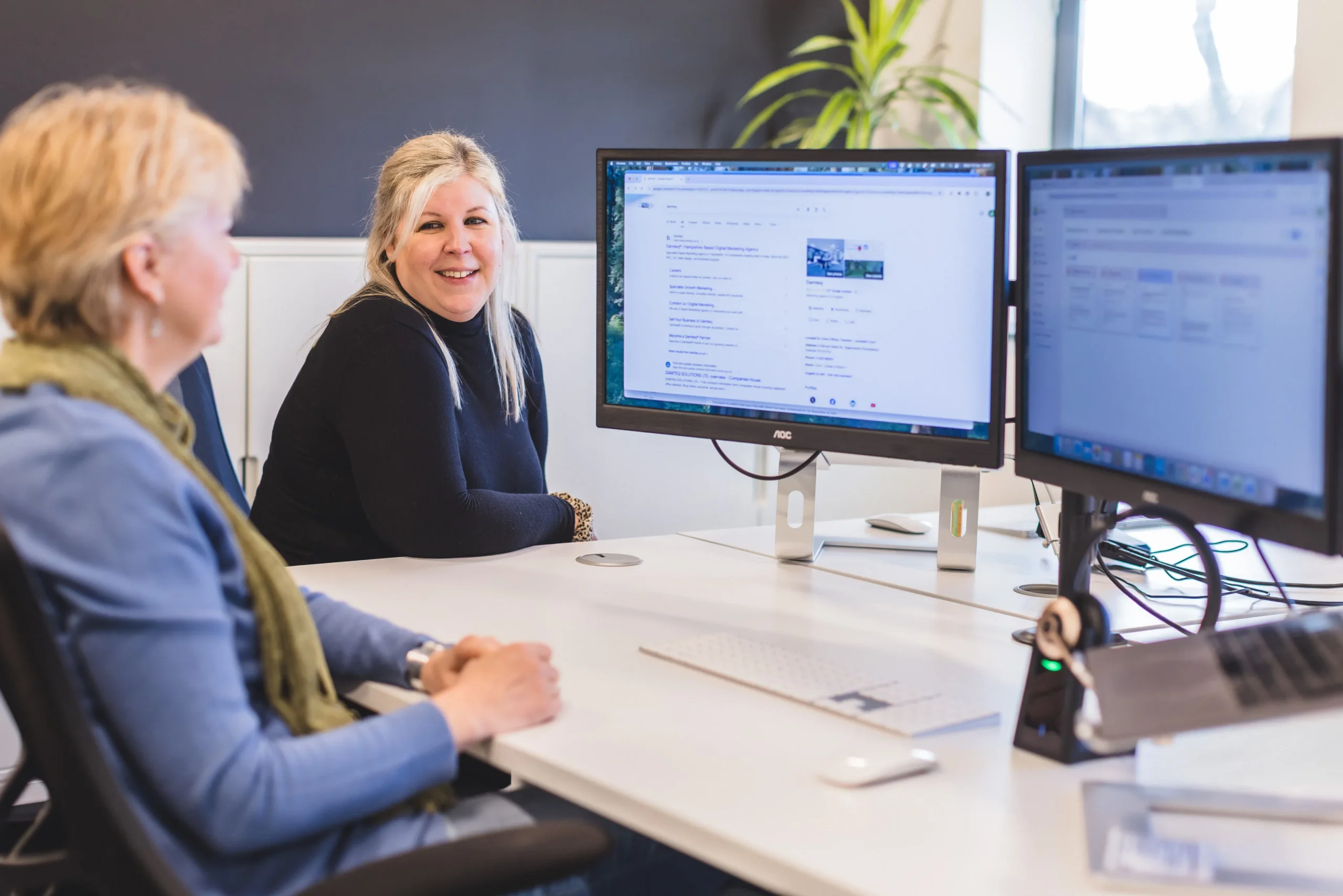 Sarah and Amanda sat at their desks collaborating
