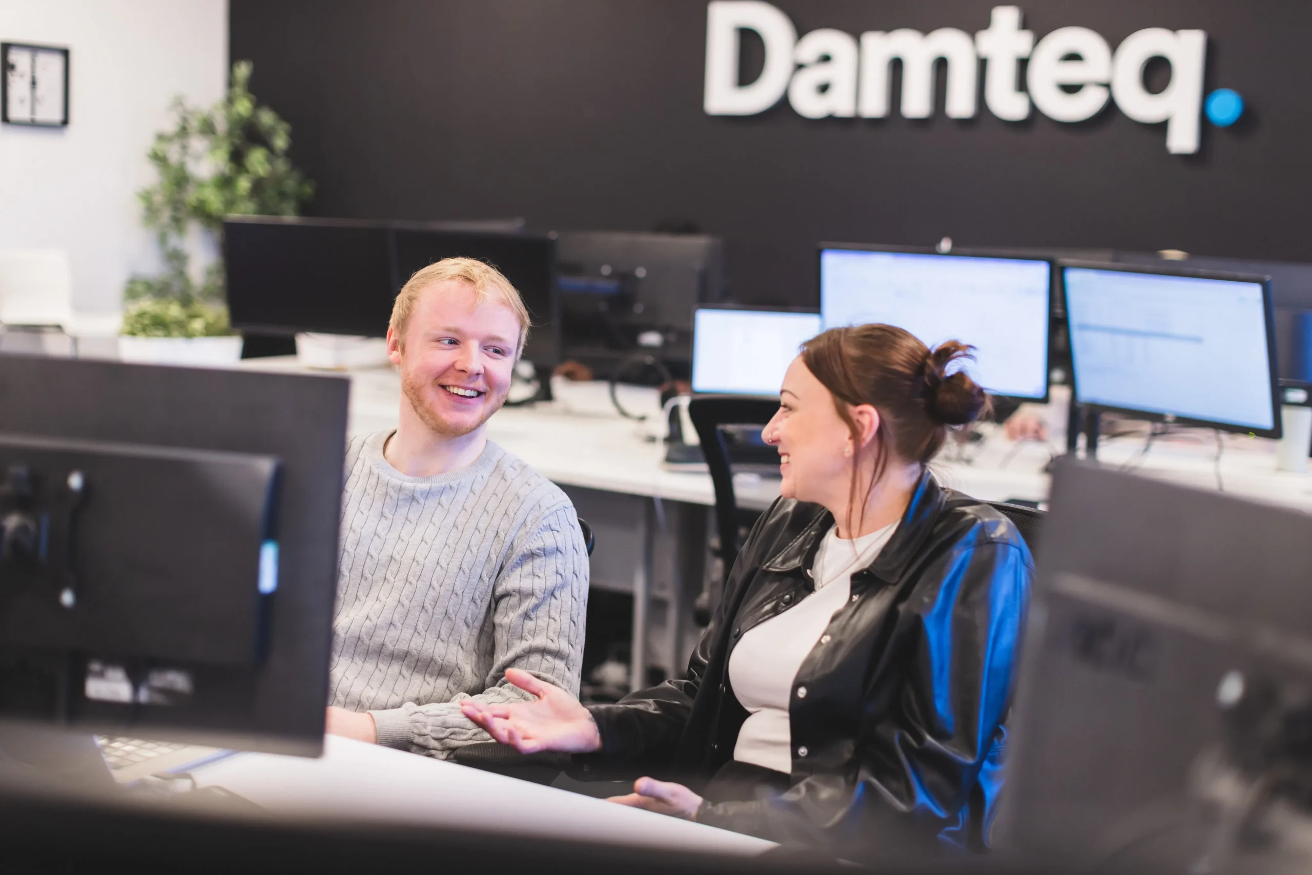 Patryk and Gemma, collaborating at a desk in front of a computer monitor