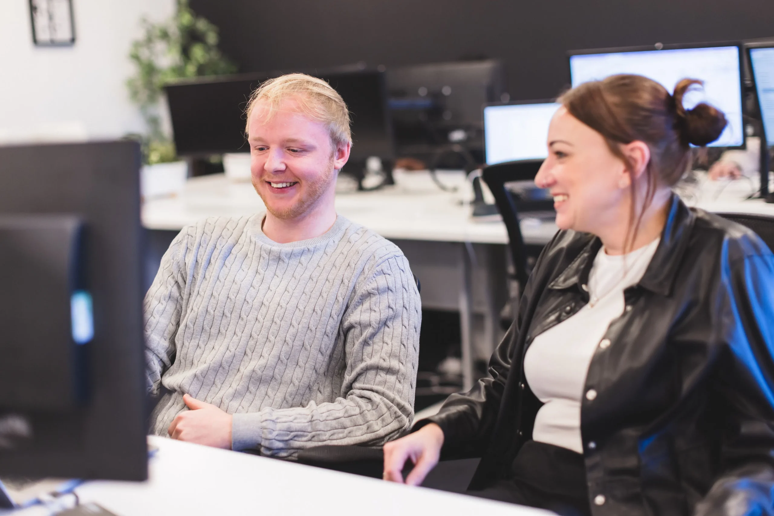 Patryk and Gemma, collaborating at a desk in front of a computer monitor