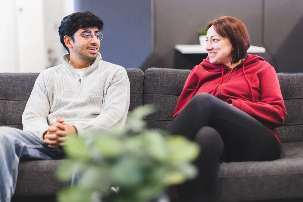 Sajan and Gemma sat talking on sofas in an office