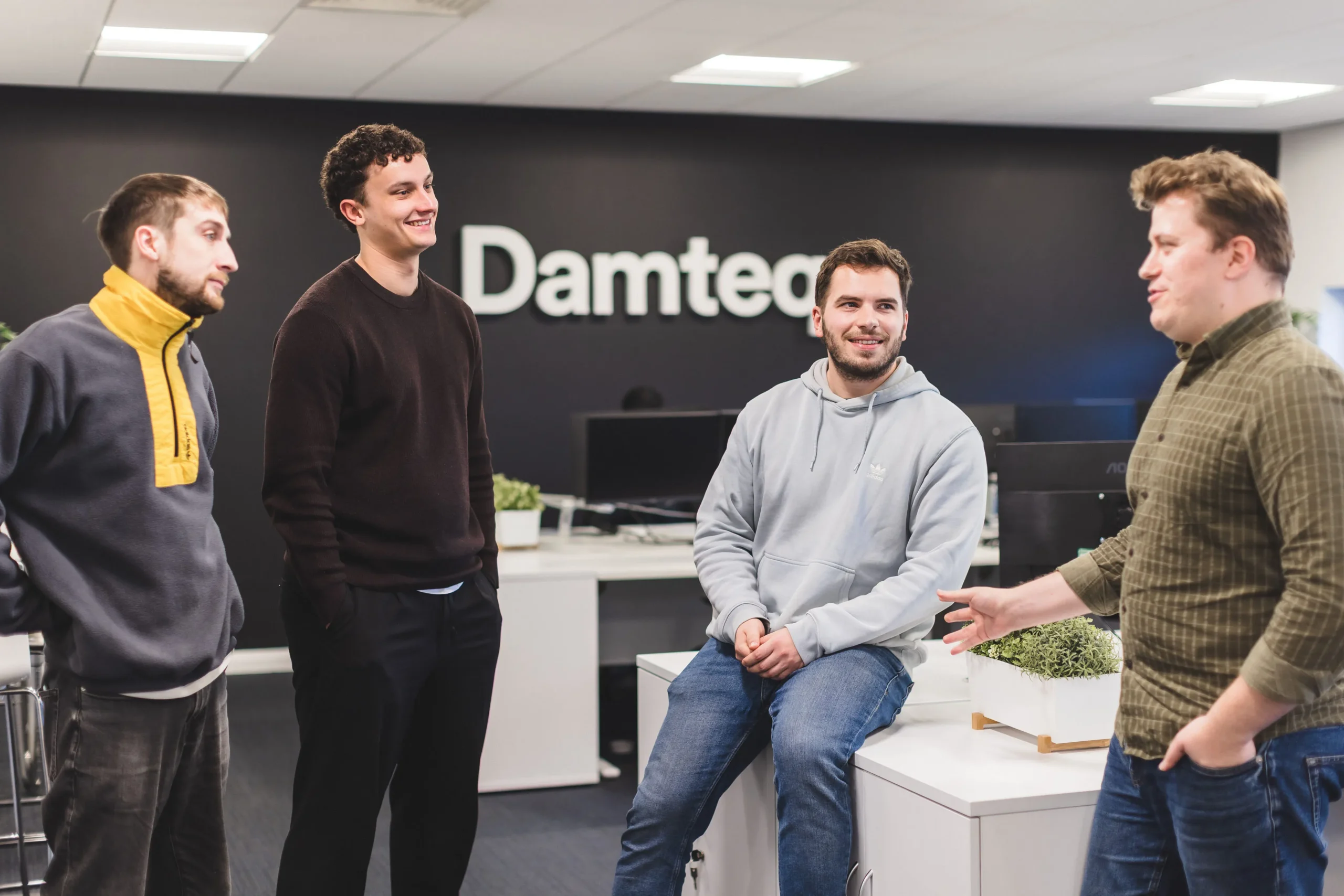 Damteq's Web and SEO team conversing in the office.